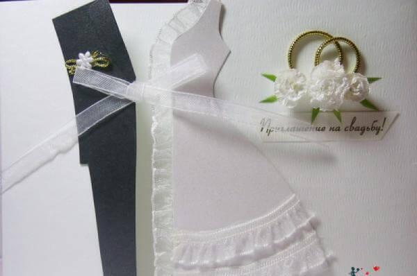 Приглашение в форме костюма жениха и платья невесты.