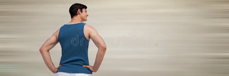 Back of man in training gear with hands on hips against blurry cream background royalty free stock photos