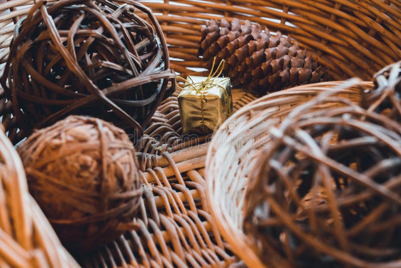 In a basket that is woven from a vine, there are balls that are also woven from a vine and cone of coniferous trees. Between them royalty free stock images