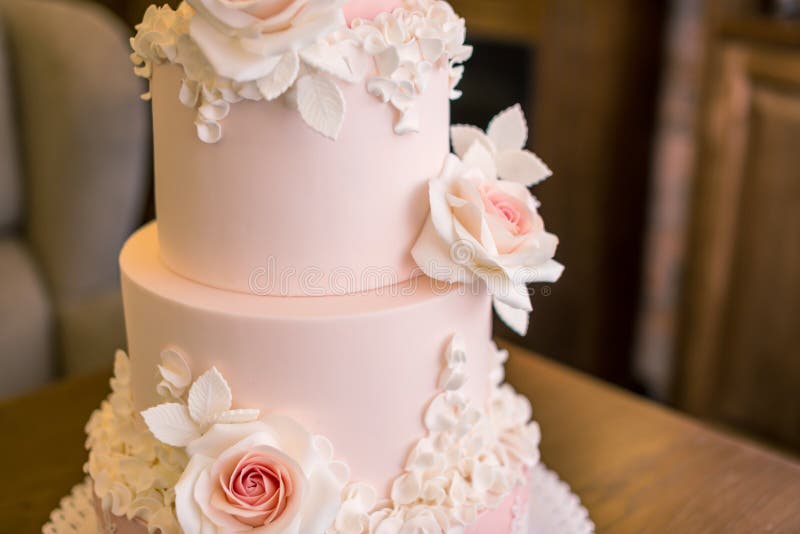 Beautiful elegant four tiered pink wedding cake decorated with roses flowers. Concept floral from sugar mastic stock photos