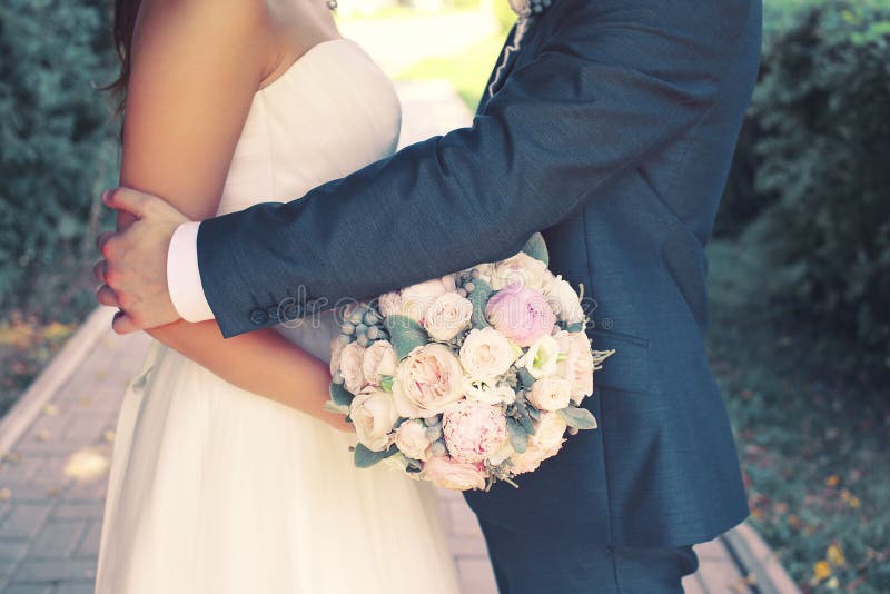 Beautiful sensual wedding couple and gentle bouquet of flowers stock photo