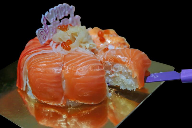 Birthday salmon cake. Top-view Happy birthday, Slice Salmon sushi cake on black background isolated royalty free stock photos