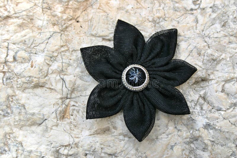 Black kanzashi fabric flower. Kanzashi are hair ornaments used in traditional Japanese hairstyles. The term kanzashi is sometimes applied to the folded cloth royalty free stock image
