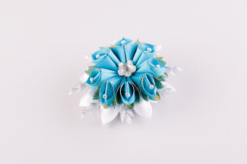 Blue and white hair clip in the shape of a flower. Blue and white hair clip made of special ribbons in the shape of a handmade flower using the kanzashi royalty free stock image