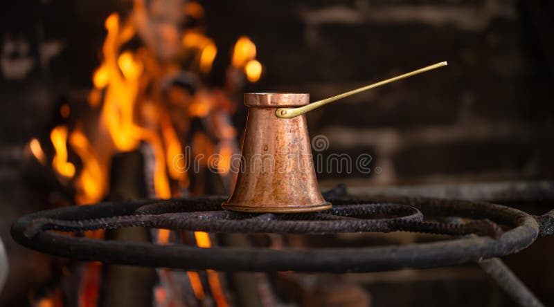 Brewing coffee in a Turk on an open fire stock images