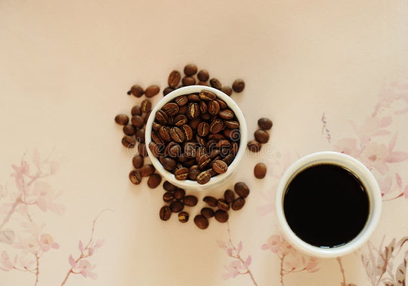 China specialty coffee concept. Two white cups: roasted beans and espresso. On chinese pattern background. Top view. China Yunnan specialty coffee concept stock photography