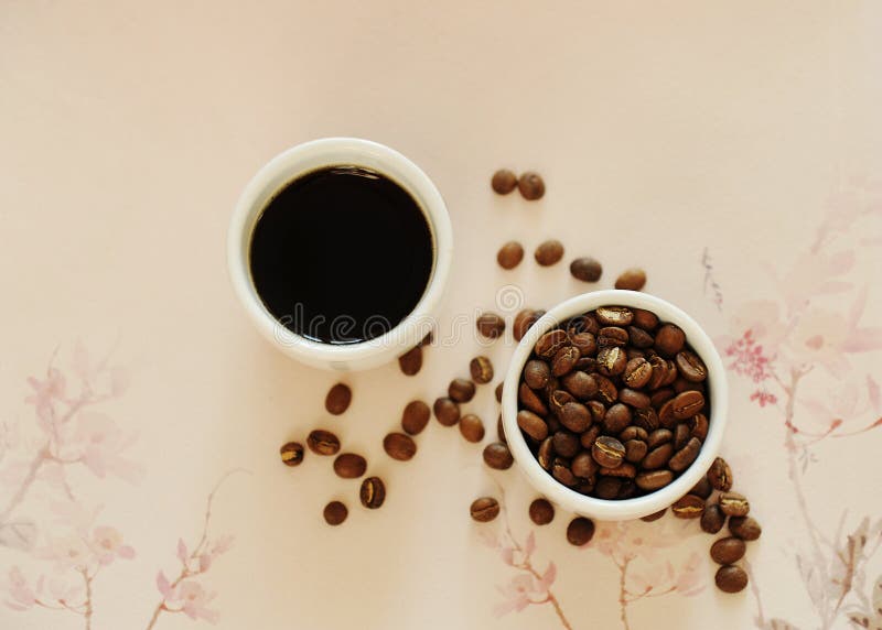 China specialty coffee concept. Two white cups: roasted beans and espresso. On chinese pattern background. Top view. China Yunnan specialty coffee concept royalty free stock photography