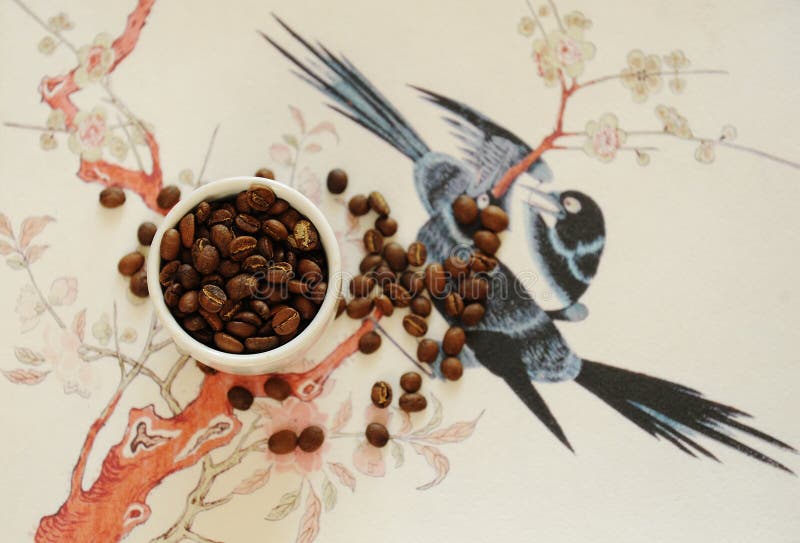 China specialty coffee concept. Roasted bean in white cup and on traditional chinese pattern background. Top view. China Yunnan specialty coffee concept. Roasted stock images