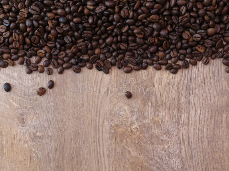 Coffee beans on fine oak tree wood texture pattern background. Space for text. Coffee beans on fine oak tree wood texture pattern background. Partially filled stock photography