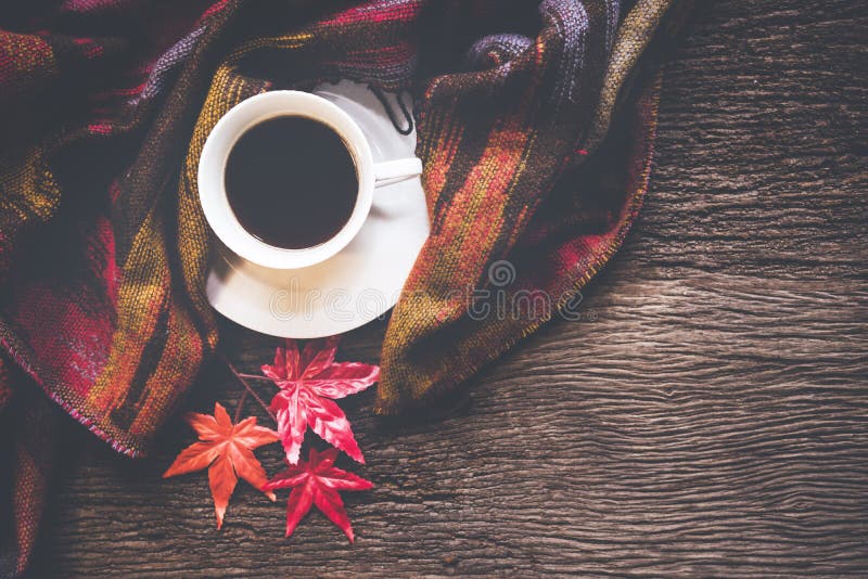 Cozy winter background, cup of hot coffee with marshmallow and leaves maple on season autumn, warm knitted sweater on old wooden b stock photography