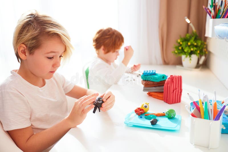 Cute kids are creating the hand crafts from modelling plasticine at kids room royalty free stock photo