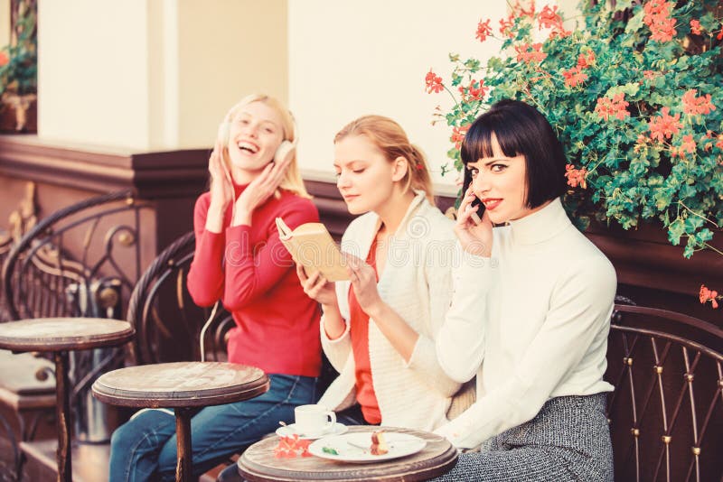 Different interests. Hobby and leisure. Group pretty women cafe terrace entertain themselves with reading speaking and. Listening. Information source. Female royalty free stock photos