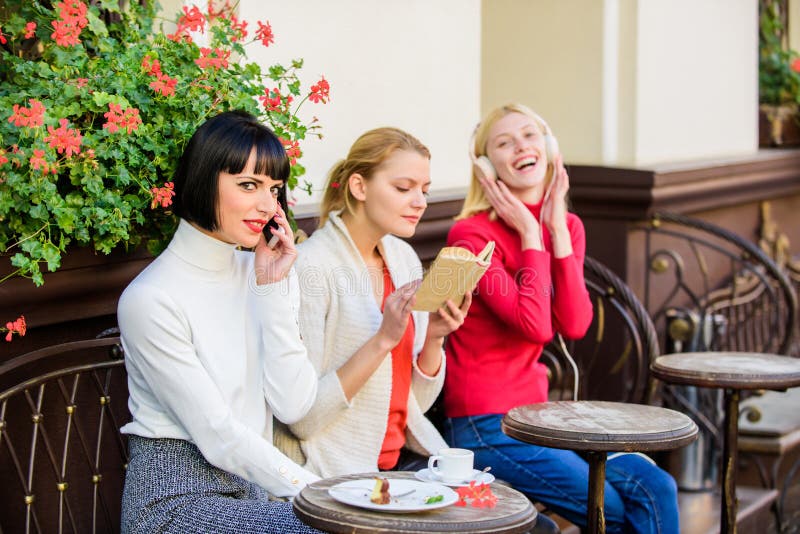 Different interests. Hobby and leisure. Group pretty women cafe terrace entertain themselves with reading speaking and. Listening. Information source. Female royalty free stock photos