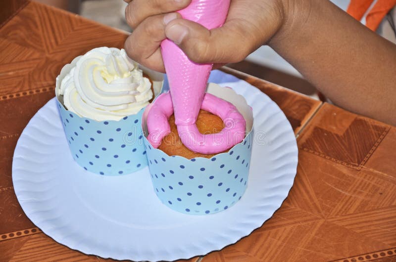 Drop sweet cream on cupcake stock photo