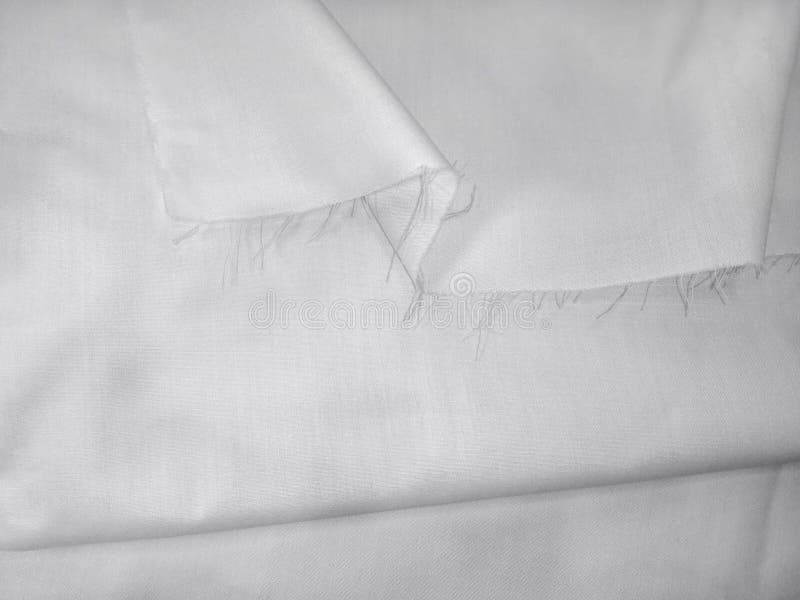 Empty clean background of white folded fabric with bending and torn hem. Textured fabric pattern for mockup, rough fabric stock photography