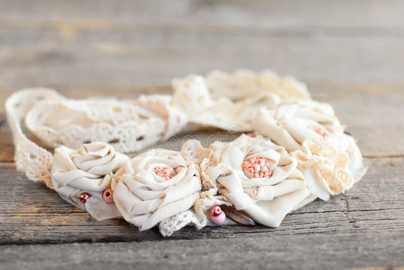 Fabric flower necklace with lace trims, beads and felt base. Summer lovely textile jewelry for women and girls. Making jewelry from recycled products. Closeup stock image