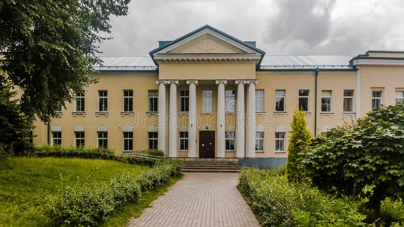 Facade of two-storey house with columns. Old beige mansion of the 18th century. Vintage estate in Russia. Dmitrov gymnasium Logos royalty free stock images