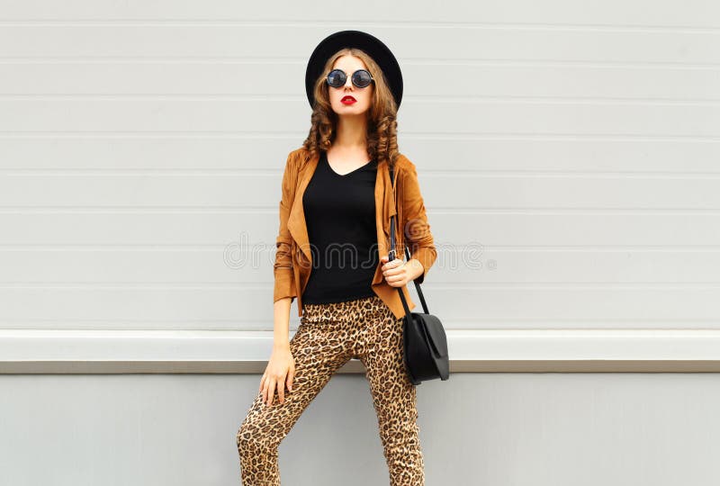Fashion look, pretty woman wearing a retro elegant hat, sunglasses, brown jacket and black handbag over background. Fashion look, pretty woman wearing a retro stock images