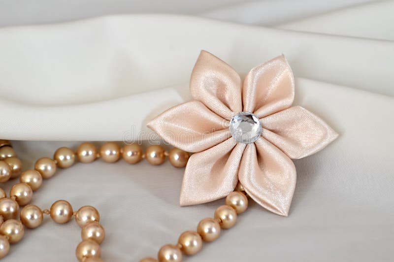 Handmade kanzashi flower and pearls. On white background stock images