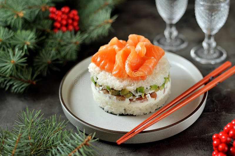 Homemade sushi cake with lightly salted salmon, avocado, soft cheese and seaweed. Christmas background. Food stock image