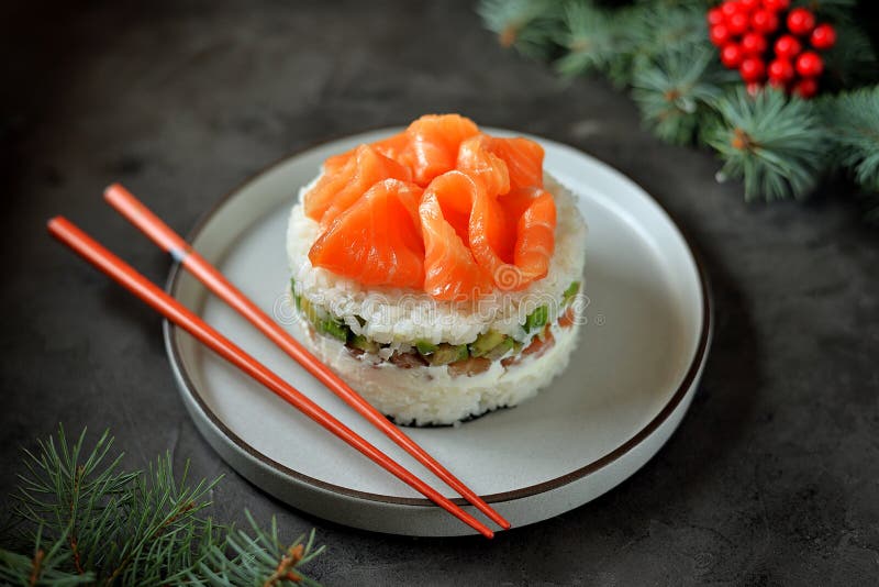Homemade sushi cake with lightly salted salmon, avocado, soft cheese and seaweed. Christmas background. Food stock photo