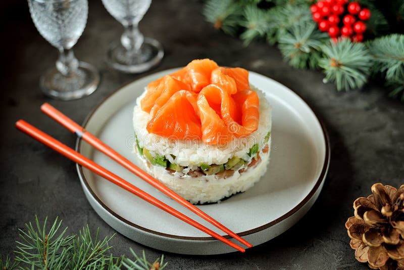 Homemade sushi cake with lightly salted salmon, avocado, soft cheese and seaweed. Christmas background. Food royalty free stock photography