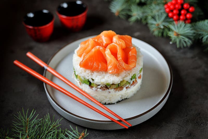 Homemade sushi cake with lightly salted salmon, avocado, soft cheese and seaweed. Christmas background. Food stock photography