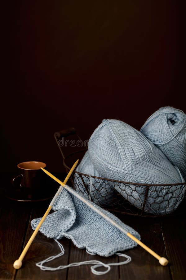 Knitting from light blue yarn and a cup of coffee. stock image