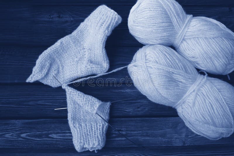 Knitting needles with thread. Tinted photo in classic blue, 2020 trend royalty free stock photo