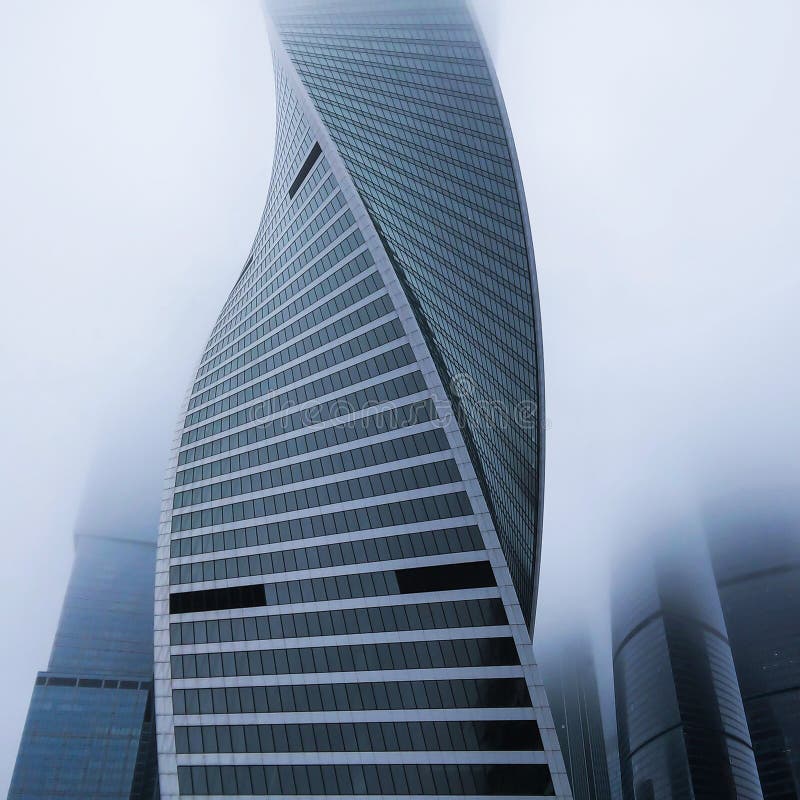 Modern tall skyscraper in dense fog, closeup. Square cropping stock photo
