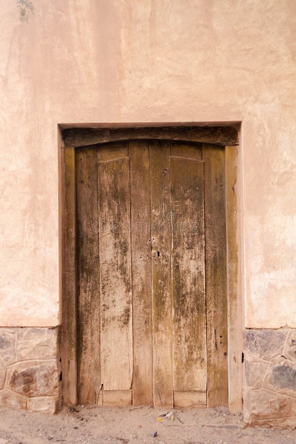 Photo closeup of old aged building made of stone masonry with aged wooden door stock photos
