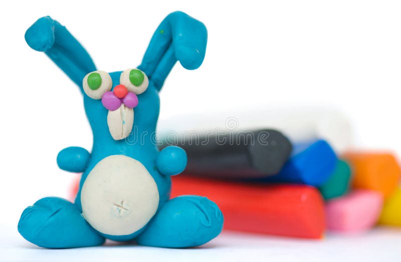 Plasticine rabbit. Funny blue plasticine rabbit on the background pieces of plasticine royalty free stock images