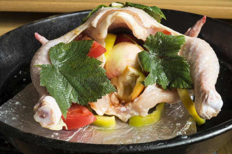 Preparation of the stuffed hen on pan stock photography