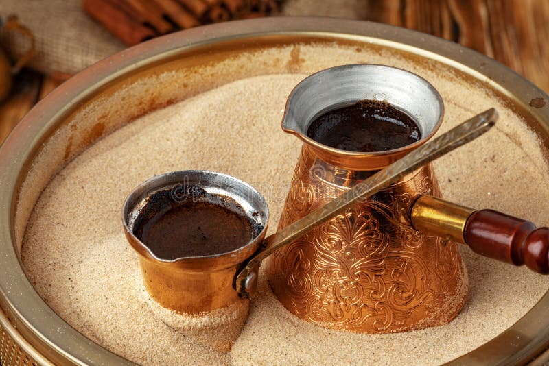 Process of preparation of coffee in turk in cezve on sand royalty free stock images