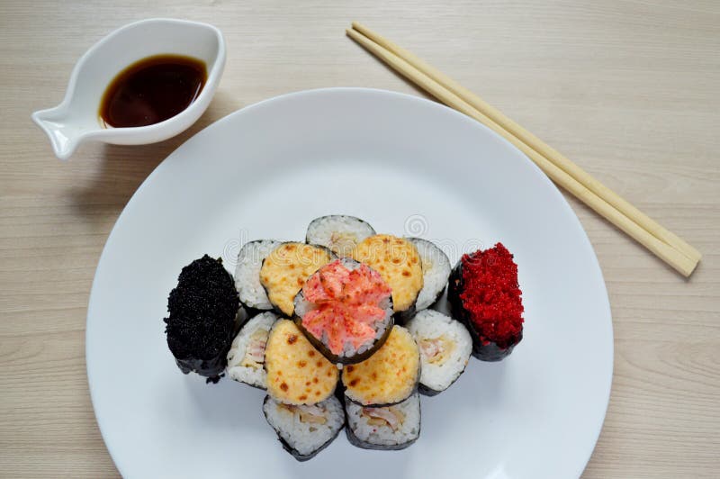 Rolls and sushi folded in the form of a cake on a white plate. Sushi set on a white plate. Rolls and sushi folded in the form of a cake on a white plate stock image