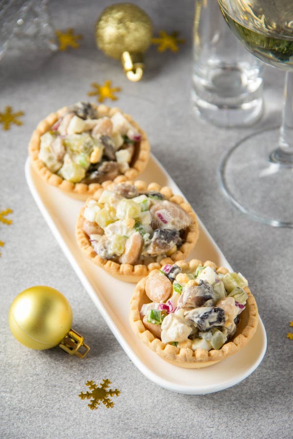 Russian salad with meat in tartlet. With potatoes, egg, cucumber, onion, mushrooms and mayonnaise. Olivier for new year table, royalty free stock image