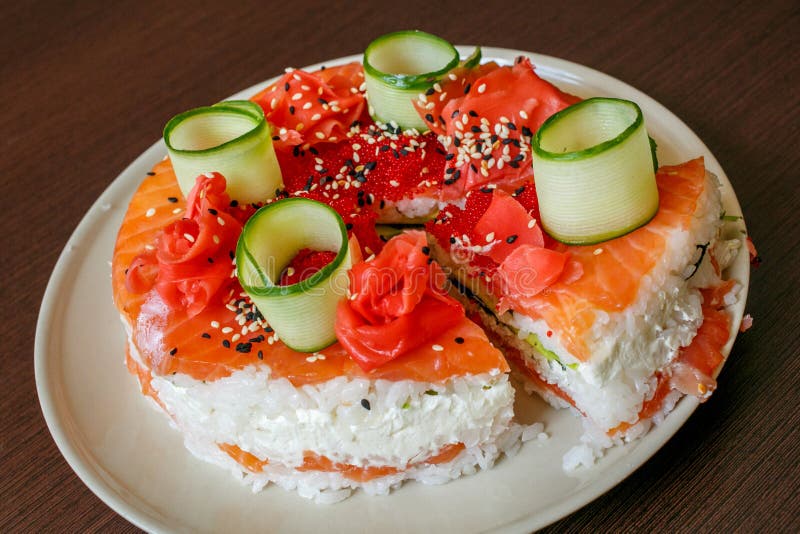 Salmon Sushi Cake with , avocado, caviar, nori, sesame. Salmon Sushi Cake with nigiri, soy sauce, cucumber, salmon, avocado, caviar nori sesame Cutoff stock image
