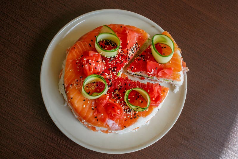 Salmon Sushi Cake with avocado, caviar, nori, sesame. Salmon Sushi Cake with nigiri, soy sauce, cucumber, salmon, avocado, caviar, nori sesame Top view stock images