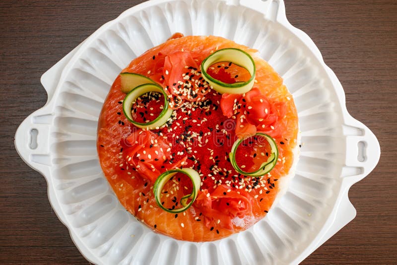 Salmon Sushi Cake with avocado, caviar, nori, sesame. Salmon Sushi Cake with nigiri, soy sauce, cucumber, salmon, avocado, caviar, nori sesame Top view royalty free stock photography