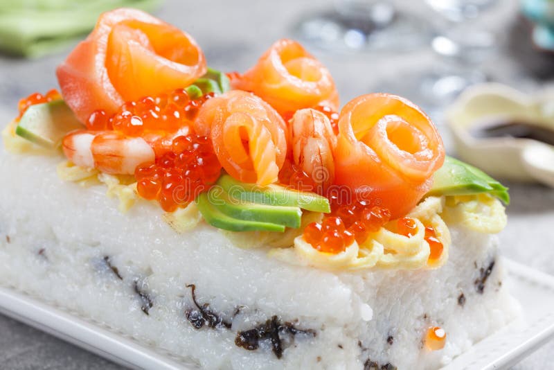 Salmon Sushi Cake. With shrimp, red caviar and avocado royalty free stock photo