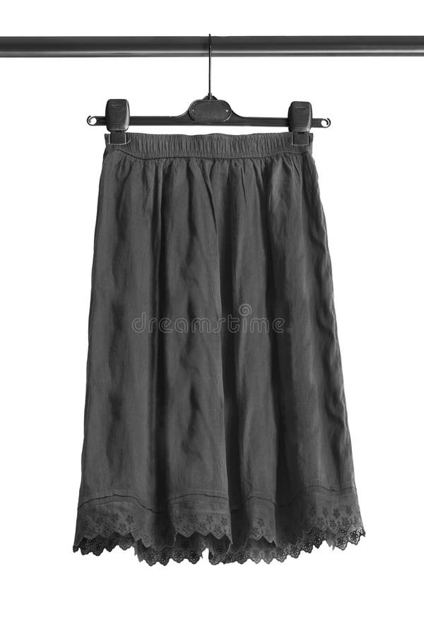 Skirt on hanger isolated. Black cotton flared skirt hanging on clothes rack isolated over white stock image