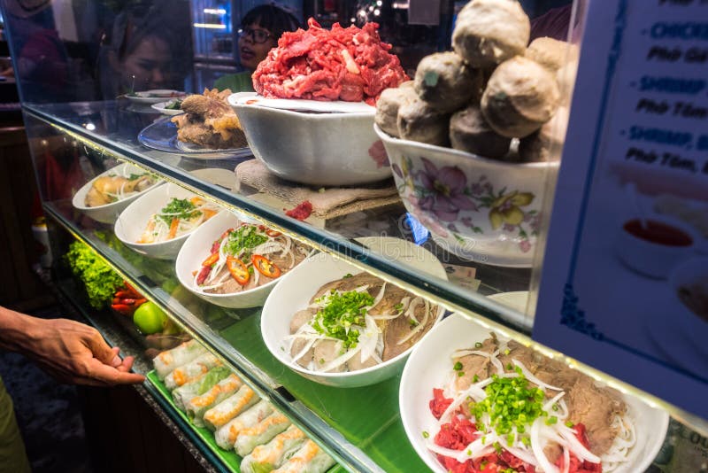 Street food stand with plates filled with soup pho ingredients stock photo