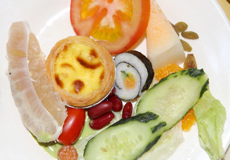 Sushi ,tomato,cake and fruit. In a dish royalty free stock photography