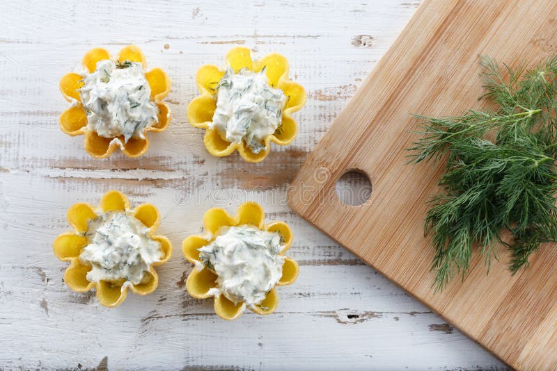 Tartlets filled with cheese and dill salad against rustic wooden background royalty free stock images