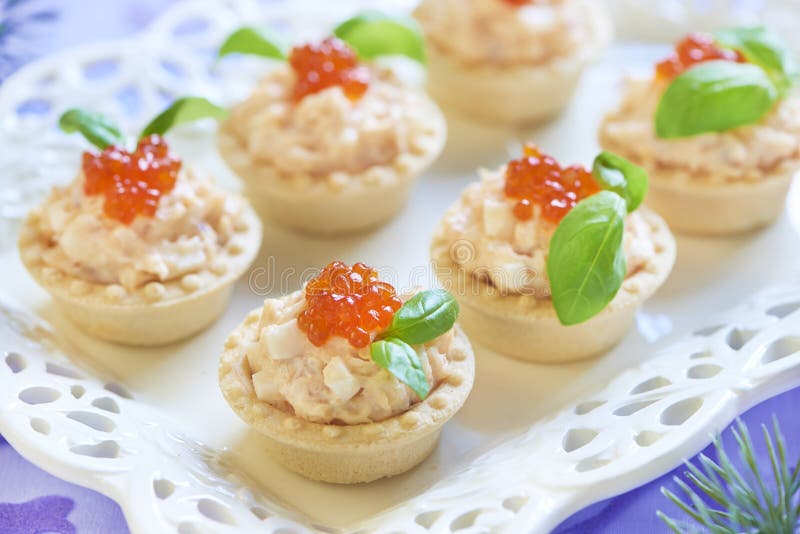 Tartlets with seafood salad, red caviar and basil stock photography