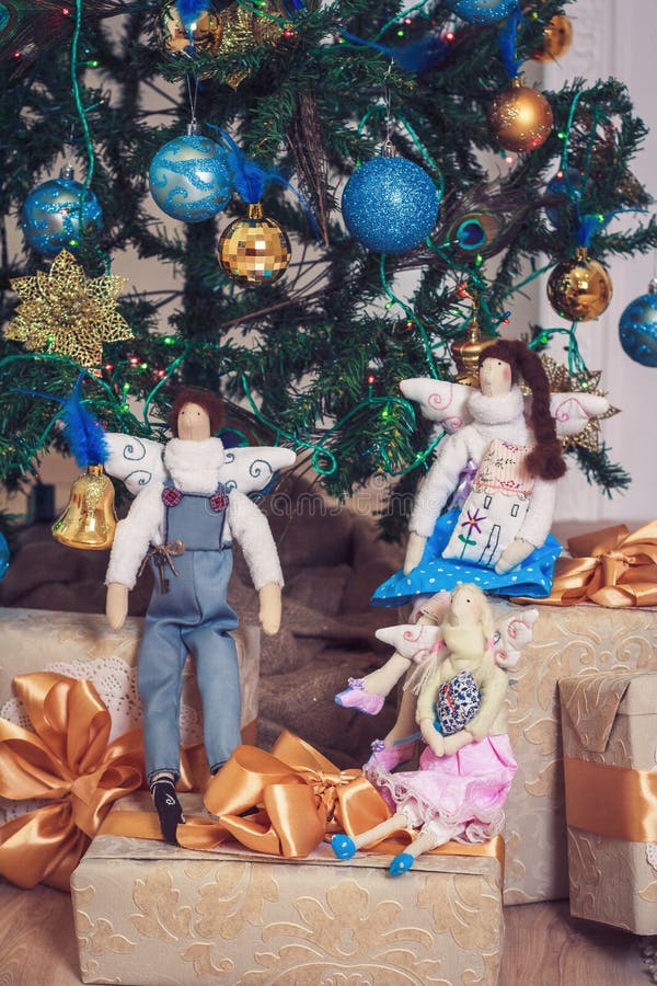 Three funny tilda angels sitting on new year gifts stock photography