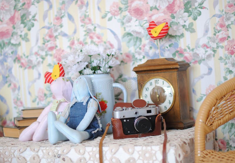 Vintage sweet interior. Camera, tilde toys, stack of books and a kettle with flowers daisies. royalty free stock photos