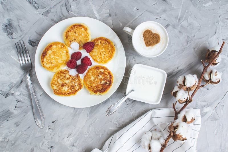 White Cup of Coffee Cappuccino with Heart Pattern of Cinnamon, Cottage Cheese Pancakes with Raspberries. Healthy Breakfast, Traditional Food Valentines day royalty free stock images