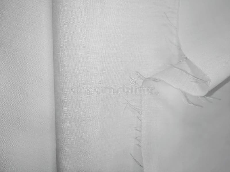 White texture of folded natural fabric with a crease and cut edge. Empty textured textile background royalty free stock images