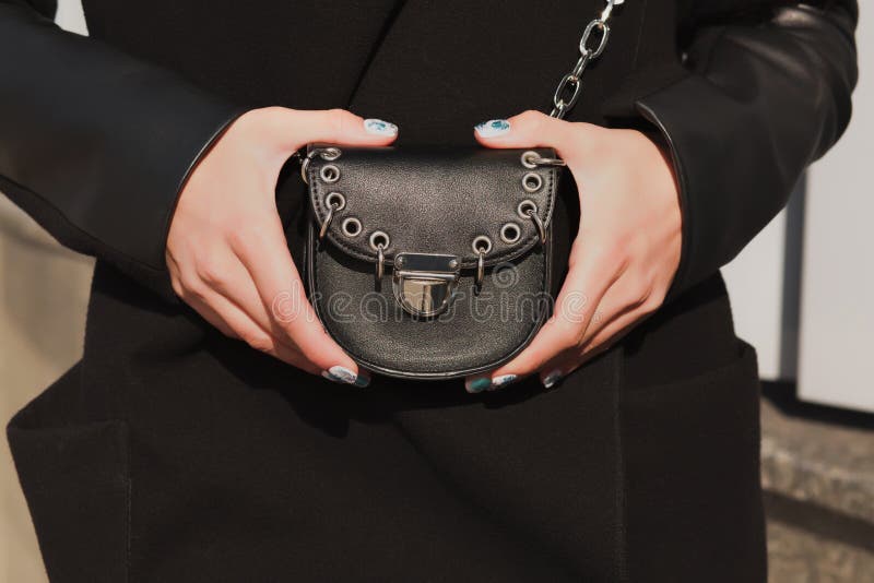 Woman`s hands holding small fashionable handbag at the backgroun stock images